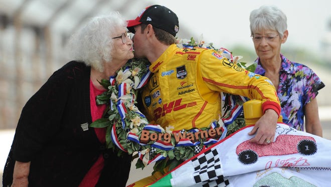 Jeanetta Holder, the quilt lady get a kiss from Indianapolis 500 winner Ryan Hunter-Reay at the winning car photo shoot, .Monday  May 26, 2014 at The Indianapolis Motor Speedway