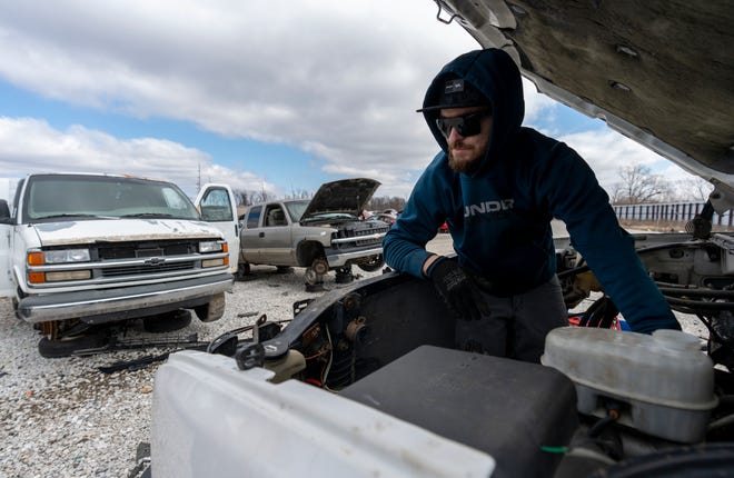 Justin Sondgeroth, Indianapolis, works on removing an engine from a truck at Pull-A-Part, in the Martindale-Brightwood neighborhood of Indianapolis, Tuesday, March 7, 2023.