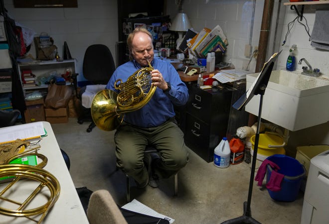 Rob Danforth, principal horn player for the Indianapolis Symphony Orchestra, practices on Thursday, Dec. 7, 2023, in the Steinmeier neighborhood of Indianapolis. Danforth and his wife bought the house partly because he likes the acoustics of the unfinished basement.