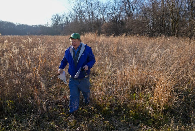 Doug Allman comes out of a field with some trash he picked up in Fishers, on Thursday, Dec. 7, 2023, at Fall Creek Woods Natural Area, which is currently closed. Other things he’s had to clean out of the park include g-string underwear hanging from nearby trees, left—he imagines—by young lovers using the park as a rendezvous of sorts.