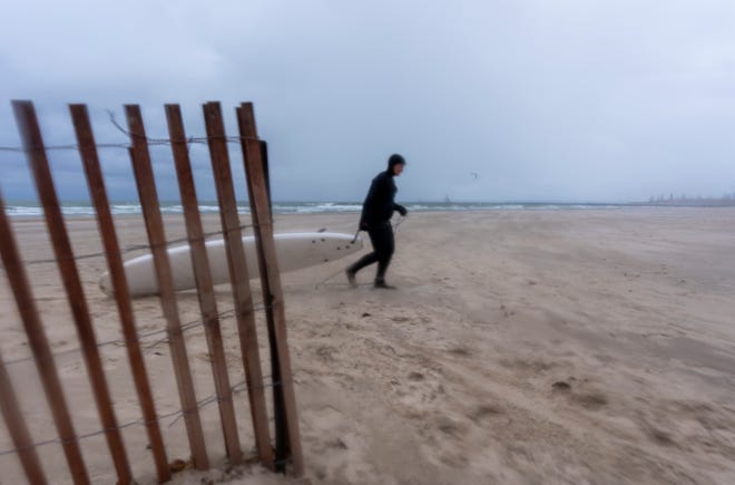 A surfer and a cold blustery day, Saturday, Nov. 12, 2022, during a surfing class on Lake Michigan just over the border in St. Joseph, Mich. Nearby Third Coast Surf Shop sponsors classes, and warm wetsuits are mandatory during colder months.