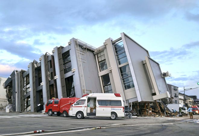 A building falls on the ground following an earthquake in Wajima, Ishikawa prefecture, Japan Tuesday, Jan. 2, 2024.