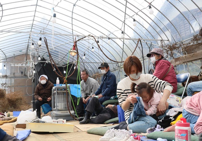 Residents shelter inside a plastic greenhouse after being evacuated in the city of Wajima, Ishikawa Prefecture, on Jan. 2, 2024, a day after a major 7.5 magnitude earthquake struck the Noto region in Ishikawa prefecture.