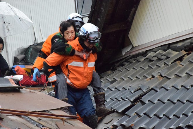 A resident (C) is carried out after being rescued by firefighters in the city of Suzu, Ishikawa prefecture, on Jan. 3, 2024, after a major 7.5 magnitude earthquake struck the Noto region in Ishikawa prefecture on New Year's Day. Japanese rescuers scrambled to search for survivors on Jan. 3 as authorities warned of landslides and heavy rain after a powerful earthquake that killed at least 62 people.