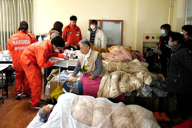 Medical staffers attend evacuees at a temporary evacuation center in Suzu in the Noto peninsula facing the Sea of Japan, northwest of Tokyo, Wednesday, Jan. 3, 2024, following Monday's deadly earthquake.