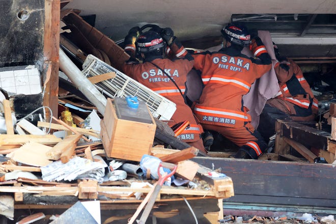 Firefighters work at the scene of a collapsed building in the city of Wajima, Ishikawa prefecture, on Jan. 3, 2024, after a major 7.5 magnitude earthquake struck the Noto region in Ishikawa prefecture on New Year's Day. Japanese rescuers scrambled to search for survivors on Jan. 3 as authorities warned of landslides and heavy rain after a powerful earthquake that killed at least 64 people.