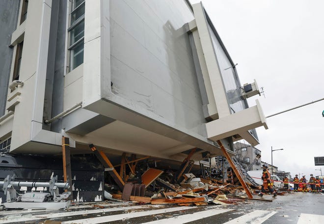 Firefighters search a fallen building hit by earthquakes in Wajima, Ishikawa prefecture, Japan, Wednesday, Jan. 3, 2024. A series of powerful earthquakes that hit western Japan left multiple people dead Wednesday as rescue workers fought to save those feared trapped under the rubble of collapsed buildings.