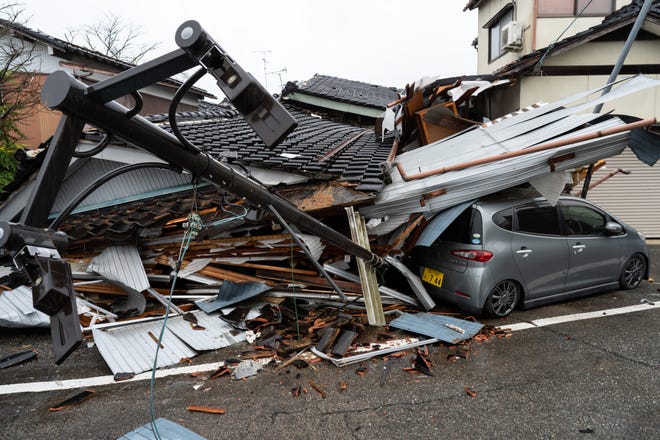 A car is seen under a collapsed house following an earthquake on Jan. 3, 2024 in Anamizu, Japan. A series of major earthquakes have reportedly killed at least 48 people, injured dozens more, and destroyed a large amount of homes. The earthquakes, the biggest measuring 7.1 magnitude, hit the areas around Ishikawa, Toyama, and Niigata in central Japan on Monday.
