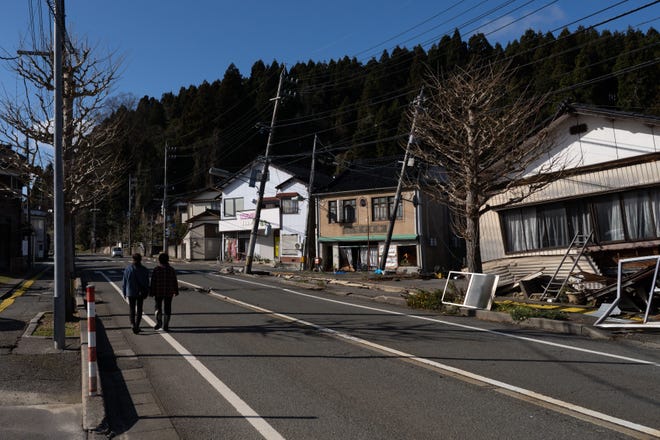A couple walks past damaged houses in the aftermath of an earthquake on New Year's Day on Jan. 4, 2024, in Anamizu, Japan. A series of major earthquakes have reportedly killed at least 78 people, injured dozens more, and destroyed a large amount of homes. The earthquakes, the biggest measuring 7.1 magnitude, hit the areas around Ishikawa, Toyama, and Niigata in central Japan on Monday.