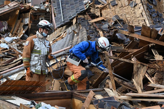 Firefighters search for people in the rubble of a collapsed house in the city of Wajima, Ishikawa prefecture on January 4, 2024, after a major 7.5 magnitude earthquake struck the Noto region in Ishikawa prefecture on New Year's Day. More than 50 people were reported missing January 4 as Japanese rescuers battled to reach hundreds still cut off from help three days after a devastating earthquake left at least 78 dead.