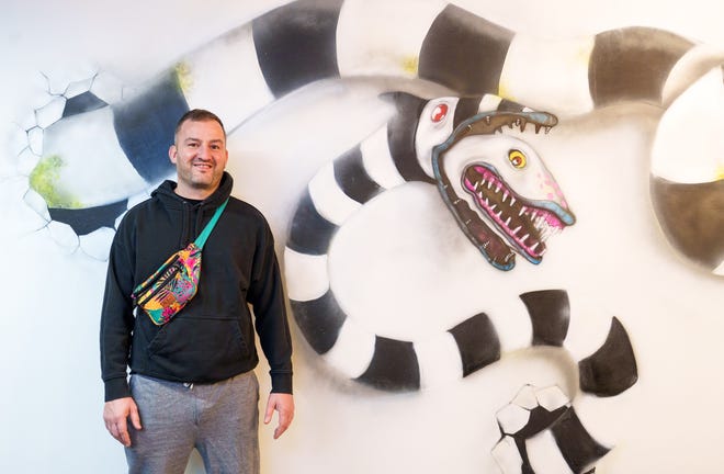 Dennis Brackenridge stands near a Beetlejuice mural Thursday, Jan. 11, 2024, painted by local artist Slice inside his new horror-themed Airbnb project in Fountain Square.