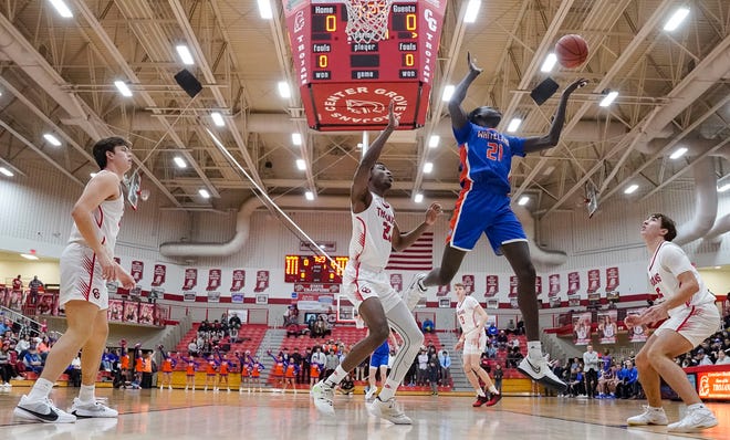 Whiteland's forward Akol Akol (21) leaps for a rebound against Center Grove Trojans forward Michael Ephraim (21) on Saturday, Jan. 13, 2024, during the Johnson County finals at Center Grove High School in Greenwood. The Center Grove Trojans defeated Whiteland, 68-43.