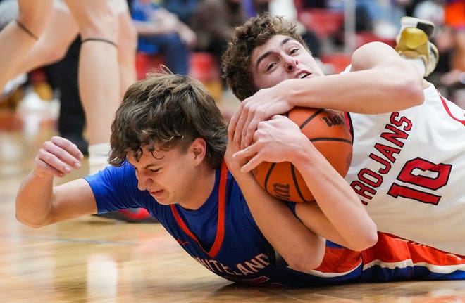 Center Grove Trojans forward Ben Chestnut (10) wrestles for the ball against Whiteland's guard Wiatt Mclaughlin (14) on Saturday, Jan. 13, 2024, during the Johnson County finals at Center Grove High School in Greenwood. The Center Grove Trojans defeated Whiteland, 68-43.