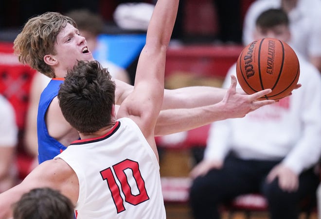 Whiteland's guard Ethan Edwards (32) puts up a layup against Center Grove Trojans forward Ben Chestnut (10) on Saturday, Jan. 13, 2024, during the Johnson County finals at Center Grove High School in Greenwood. The Center Grove Trojans defeated Whiteland, 68-43.