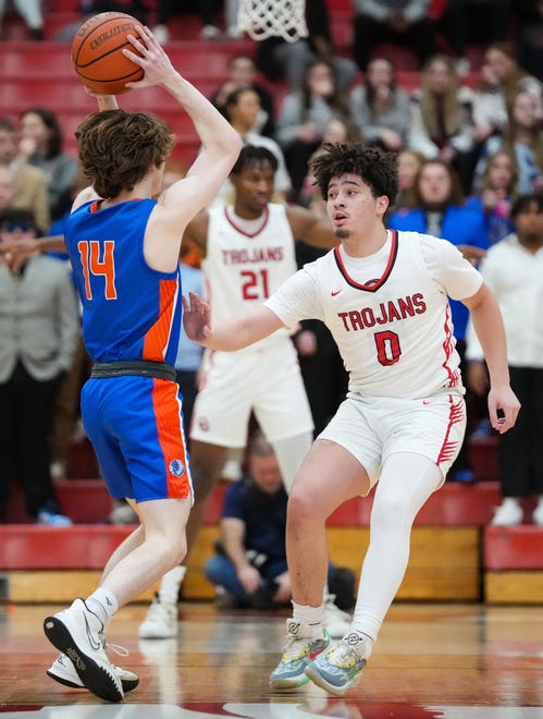 Center Grove Trojans guard Jalen Bundy (0) guards Whiteland's guard Wiatt Mclaughlin (14) on Saturday, Jan. 13, 2024, during the Johnson County finals at Center Grove High School in Greenwood. The Center Grove Trojans defeated Whiteland, 68-43.