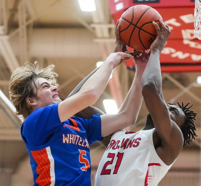 Whiteland's guard Spencer Gillespie (5) reaches for the ball against Center Grove Trojans forward Michael Ephraim (21) on Saturday, Jan. 13, 2024, during the Johnson County finals at Center Grove High School in Greenwood. The Center Grove Trojans defeated Whiteland, 68-43.
