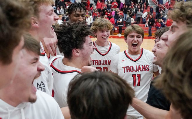 Center Grove Trojans guard Grant Long (11) yells in excitement with teammates Saturday, Jan. 13, 2024, during the Johnson County finals at Center Grove High School in Greenwood. The Center Grove Trojans defeated Whiteland, 68-43.