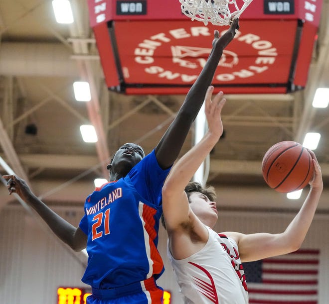 Whiteland's forward Akol Akol (21) attempts to block Center Grove Trojans forward Will Spellman (42) on Saturday, Jan. 13, 2024, during the Johnson County finals at Center Grove High School in Greenwood. The Center Grove Trojans defeated Whiteland, 68-43.