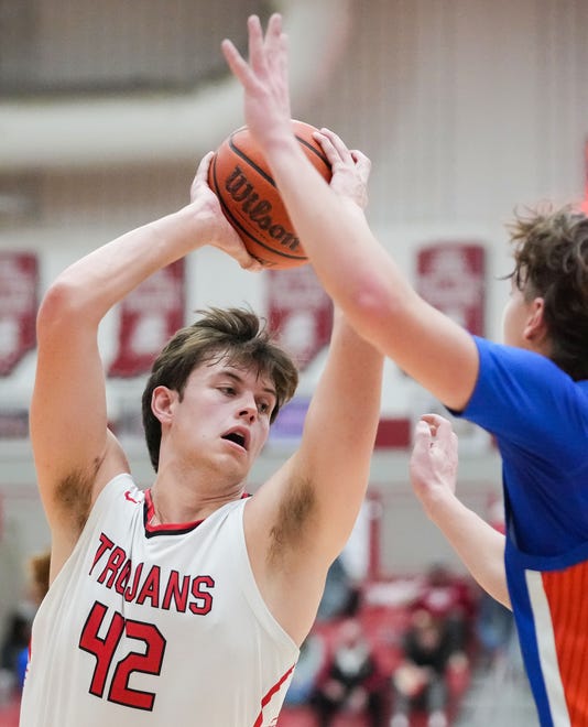 Center Grove Trojans forward Will Spellman (42) searches to pass the ball Saturday, Jan. 13, 2024, during the Johnson County finals at Center Grove High School in Greenwood. The Center Grove Trojans defeated Whiteland, 68-43.