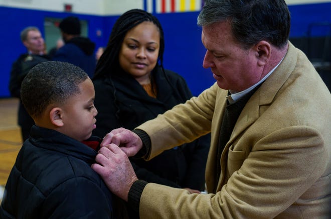 Valerie Miller watches as Indiana Attorney General Todd Rokita places a pin Monday, Jan. 15, 2024, on the jacket of her son, Chandler Miller, 9, after a press conference at Stanley Strader Park Family Center highlighting recent renovations from Citizens Energy Group’s Sharing The Dream service project and the park’s name change that was made in 2023.