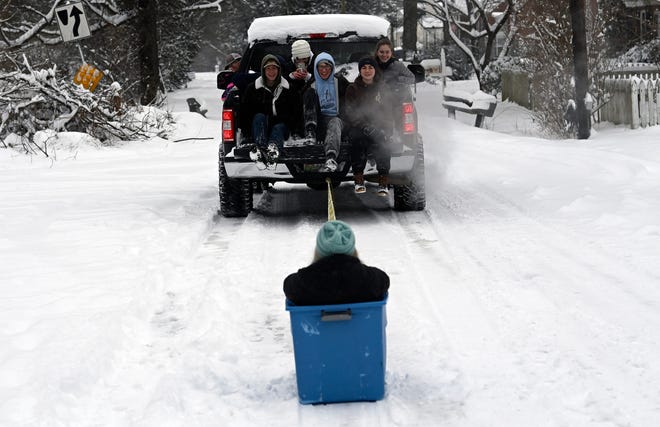 A group Lipscomb University students pull a friend in a plastic tub along Maplehurst Avenue on Monday, Jan. 15, 2024, in Nashville, Tenn. The first winter of 2024 hit Middle Tennessee and snowfall is expected to continue until Tuesday.