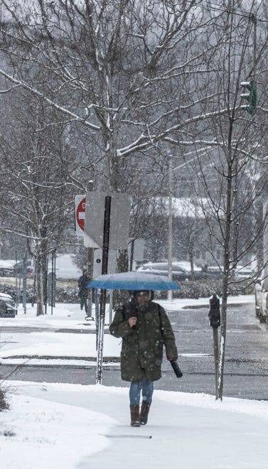 A pedestrian walks through light snow in Tarrytown after the region go several inches of overnight snow Jan. 16, 2024.